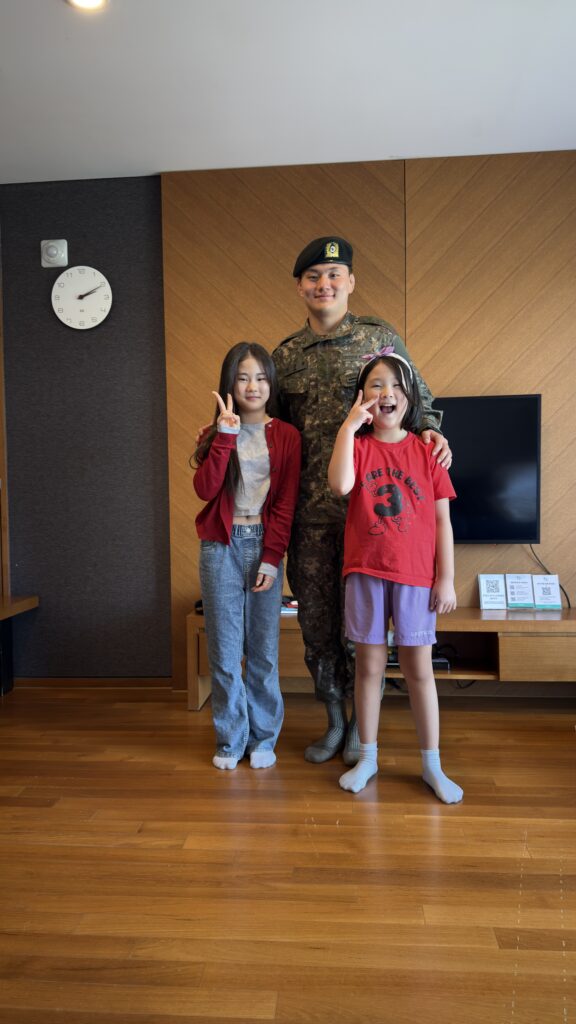 The girls posing proudly with their soldier uncle